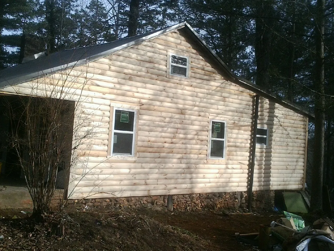 New log siding and dark metal roofing on a gable end in Snowmass Village