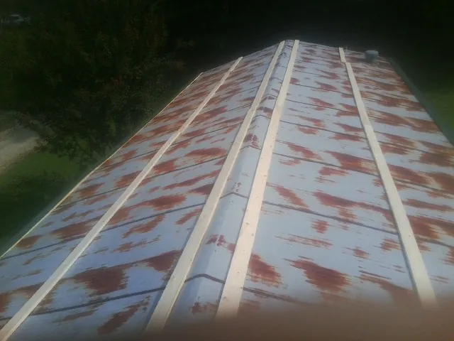 Rusted metal roof panels with new wood purlins before replacement — Storm Damage Roof Repair in Snowmass Village by Roofing Brothers