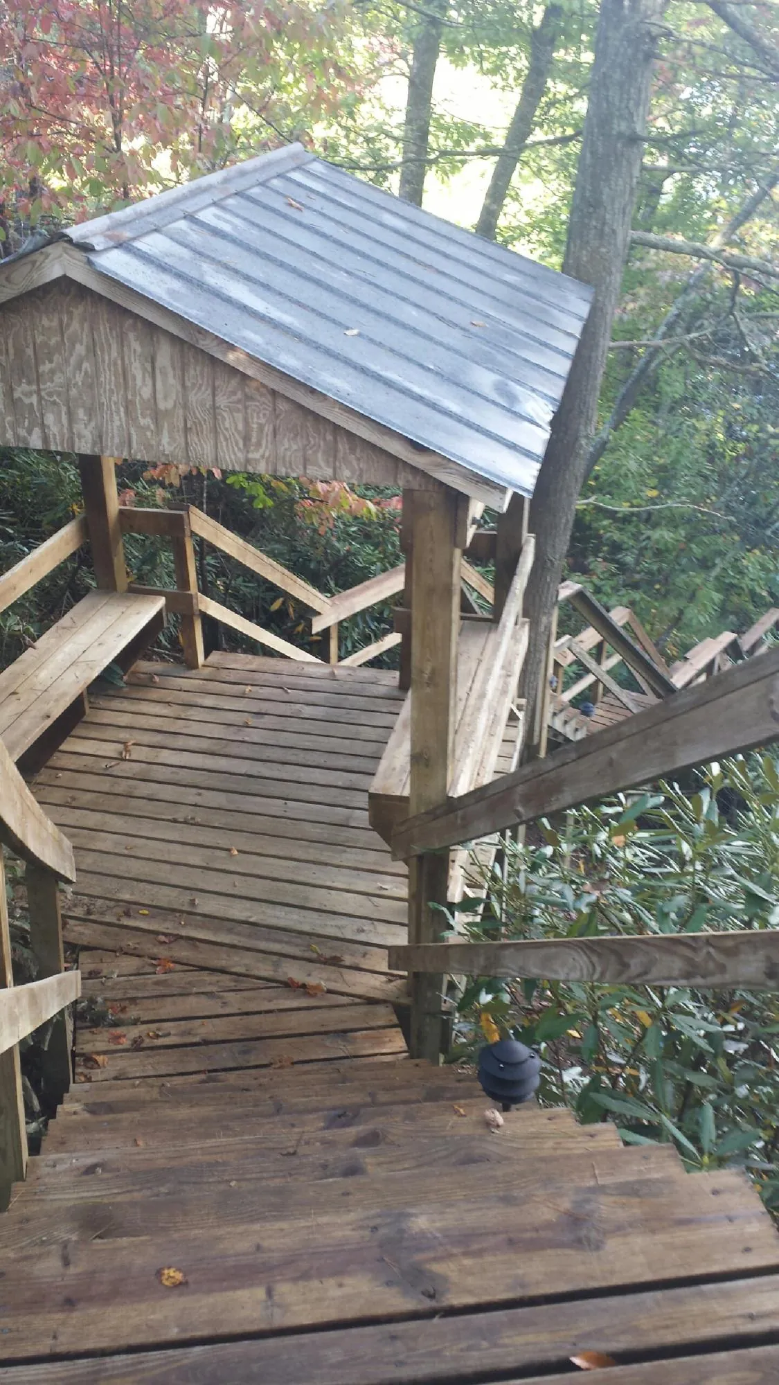 Metal roofed shelter over wooden steps on a wooded walkway — Skylight Repair & Installation work by our crew in Snowmass Village