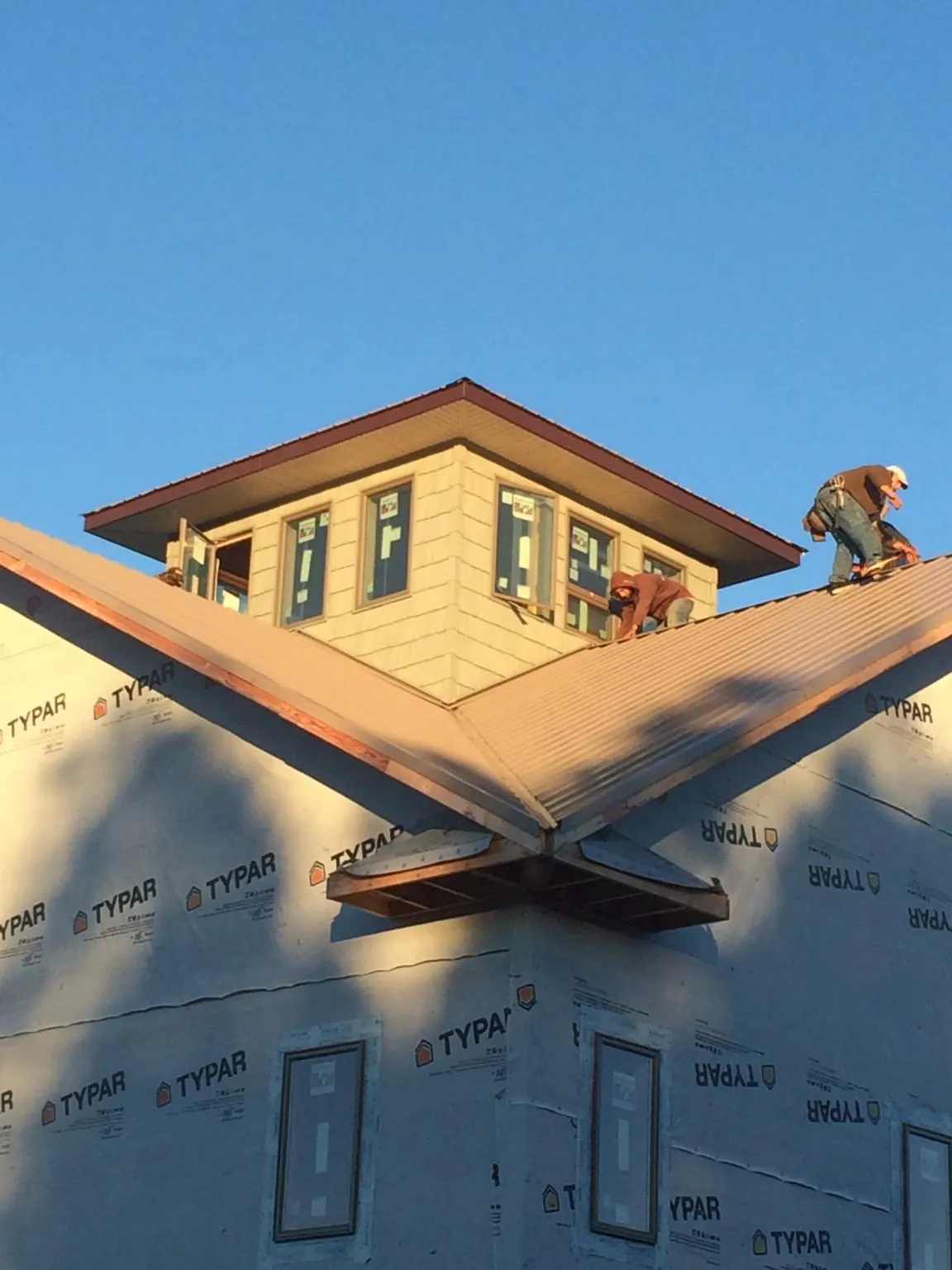 Roofers working around a rooftop cupola on a new metal roof at sunset — Roof Waterproofing in Snowmass Village by Roofing Brothers